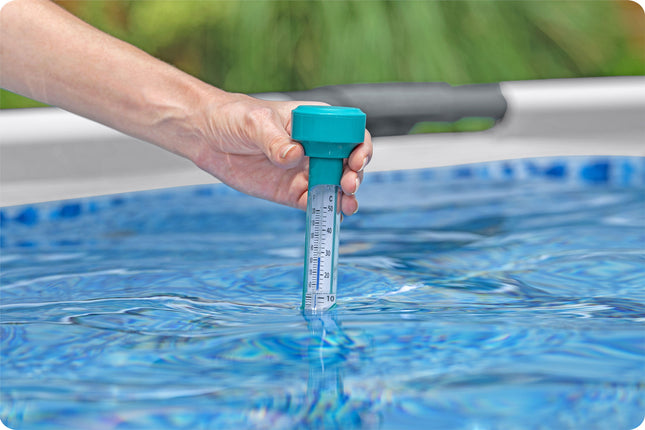 Hand plaatst de Bestway drijvende thermometer in het zwembadwater