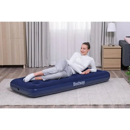 Vrouw ligt op een blauw Bestway eenpersoons luchtbed in de woonkamer