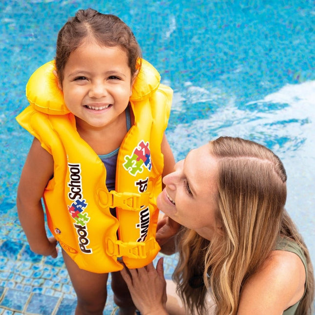 Meisje met het Intex Pool School zwemvest en moeder bij het zwembad