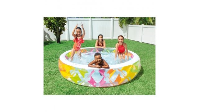 Kinderen spelen in het Intex Swim Center familiezwembad in de tuin