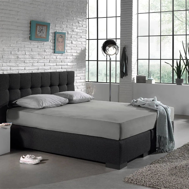 Grijs The Living Store hoeslaken op een boxspring in de slaapkamer