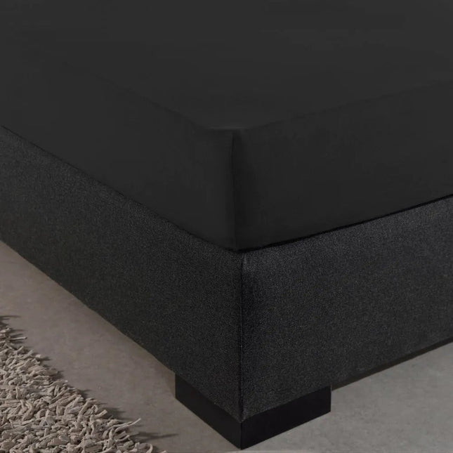 Hoek van een boxspring met zwart The Living Store hoeslaken