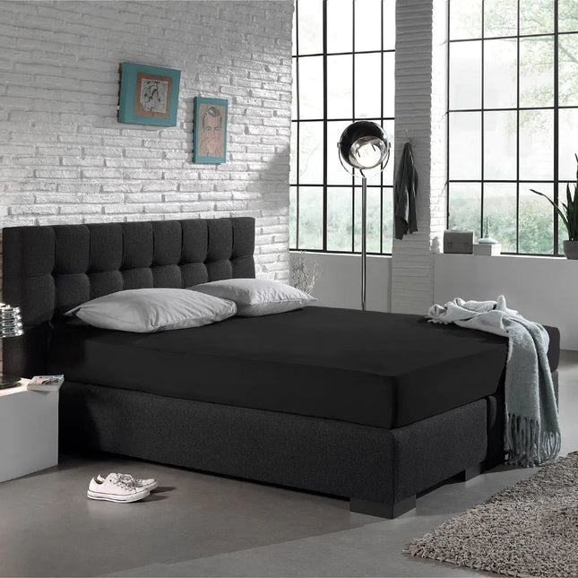 Zwart The Living Store hoeslaken op een boxspring in de slaapkamer